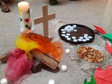 Foto von schwimmenden Teelichtern und einer großen Kerze und einem Kreuz