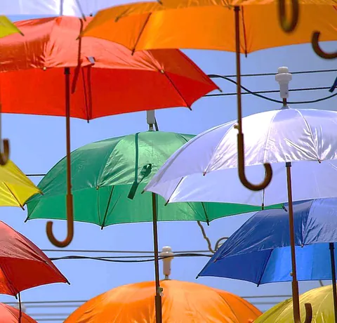 KI-Bild von mehreren farblich unterschiedlichen Regenschirmen, die zu schweben scheinen